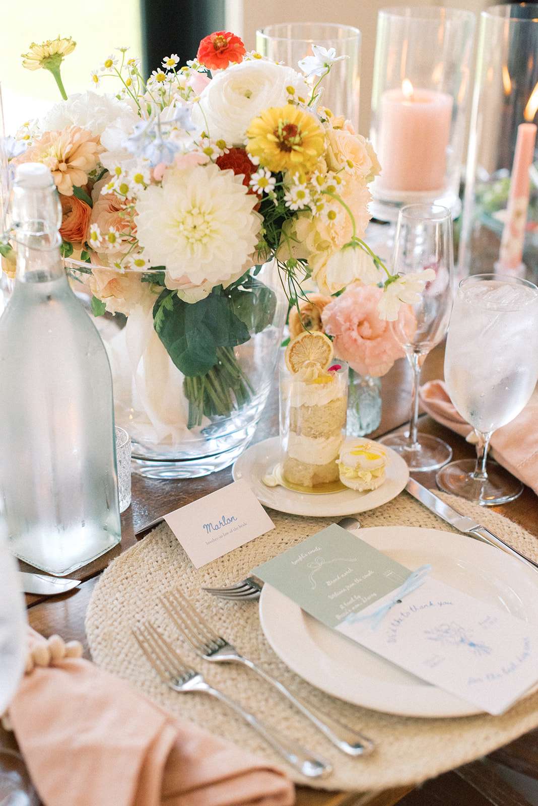 Pastel place setting detail photo with colorful flowers, pink napkins and mint menu cards. Pastel place setting detail photo with colorful flowers, pink napkins and mint menu cards.