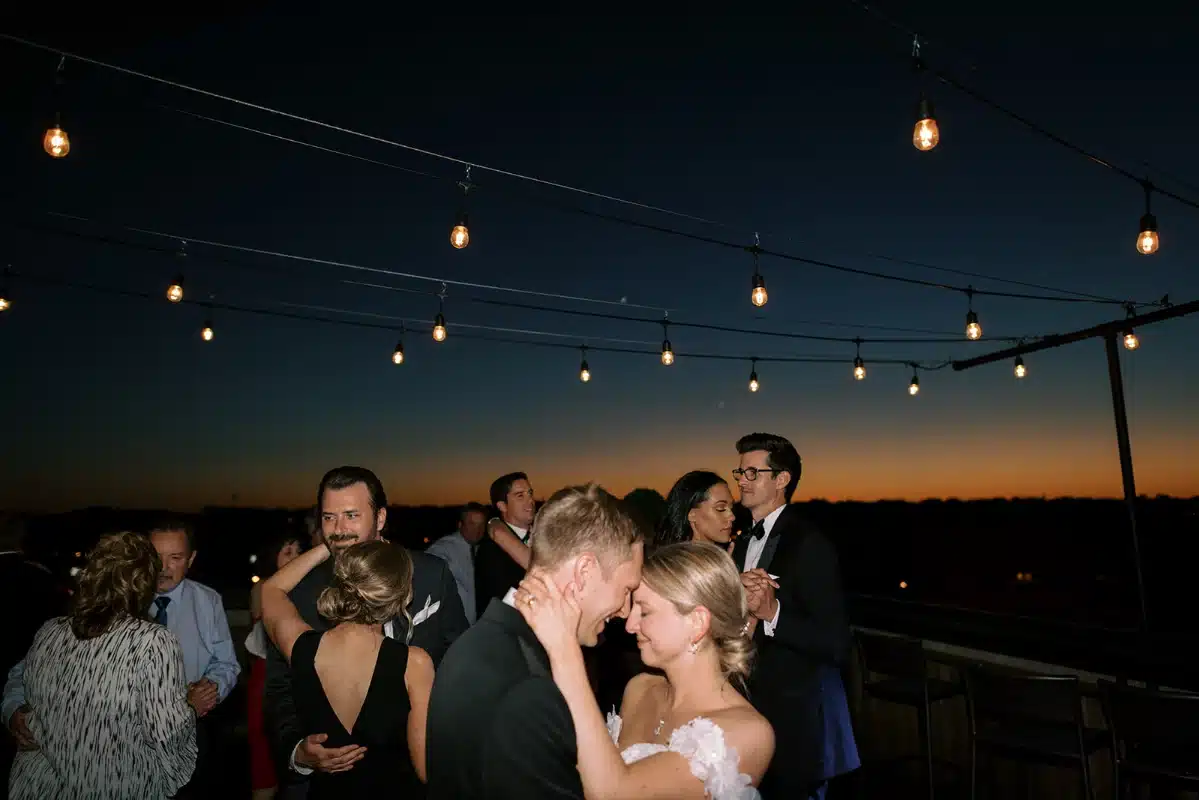 Guests dancing on the rooftop at night at Hotel Goodwin at wedding reception.