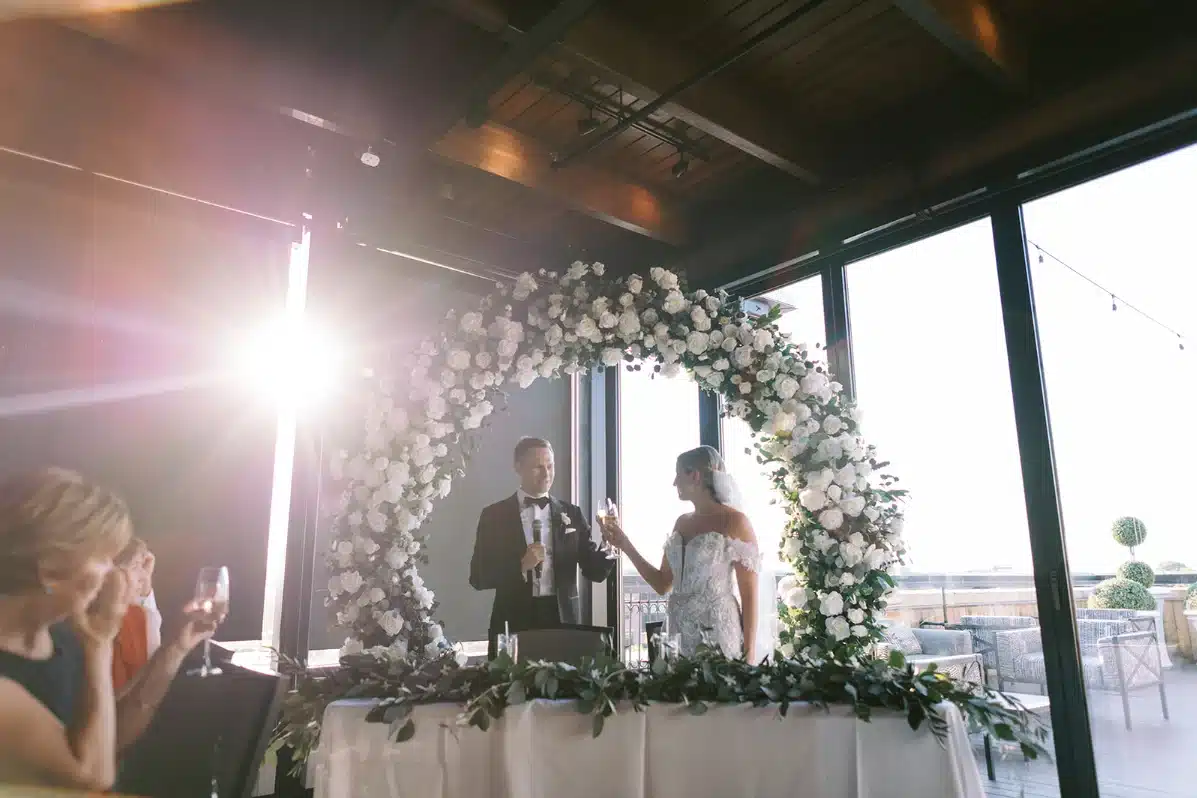Sweetheart table at Hotel Goodwin for wedding with floral arch as the backdrop.