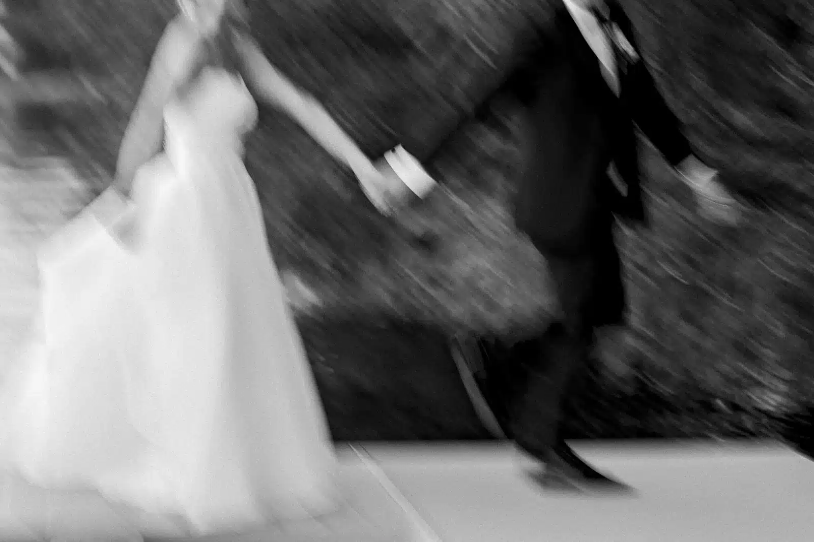 Blurry artistic shot of bride and groom running.