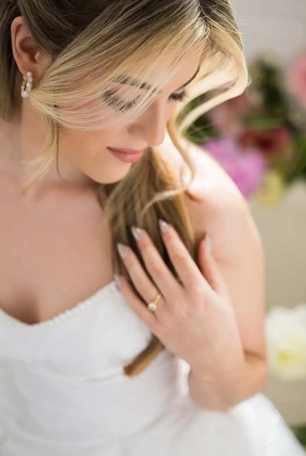 Bridal portrait of bride looking down and hand with wedding ring.