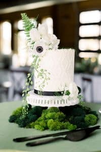 FOXTOWN STYLED SHOOT-91 White cake with intricate piped diamond details topped with floral sprigs and black-eyed beauty anemone