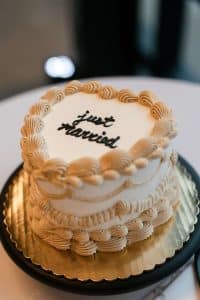 Vintage heart wedding cake with “just married” written on top in black cursive. Vintage heart wedding cake with "just married" written on top in black cursive.