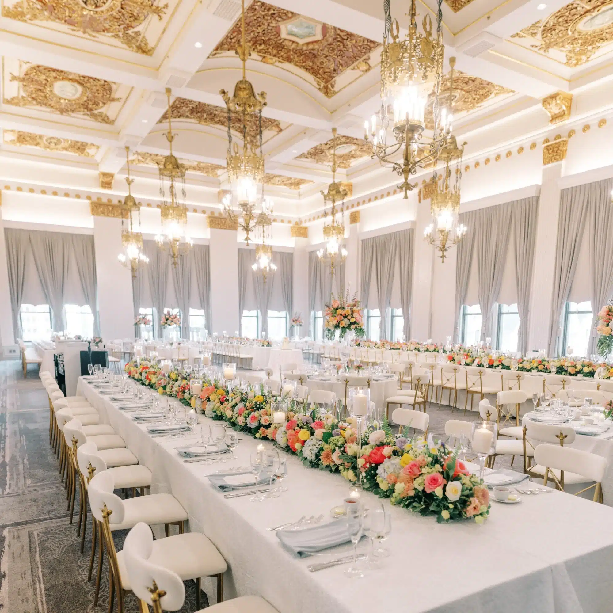 Colorful flower wedding reception at The Pfister Hotel with kings tables and colorful florals and candles draped across the table. Colorful flower wedding reception at The Pfister Hotel with kings tables and colorful florals and candles draped across the table.