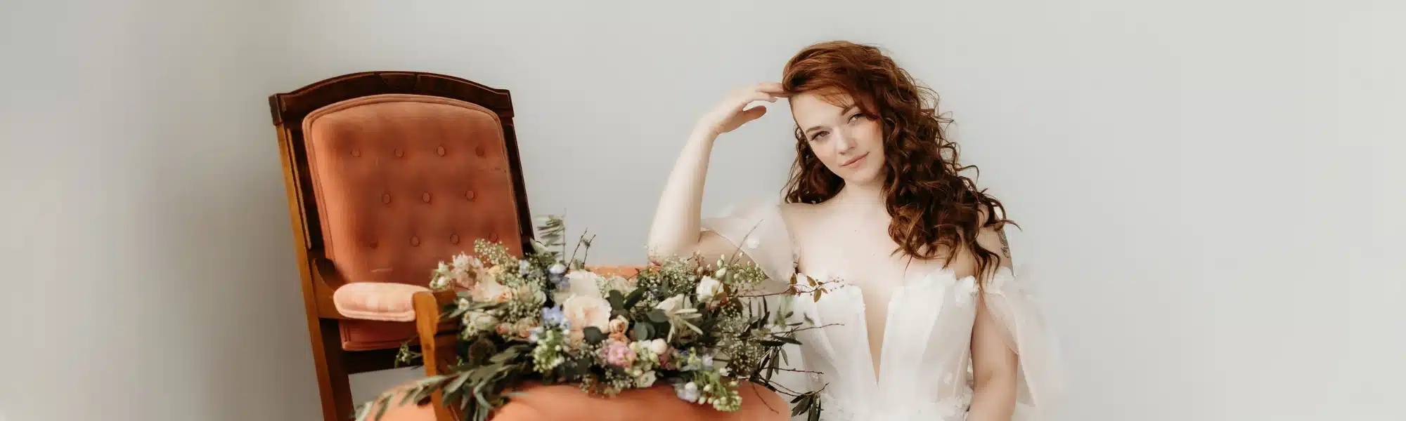 Bride leaning on pink chair with bouquet. Bride leaning on pink chair with bouquet.