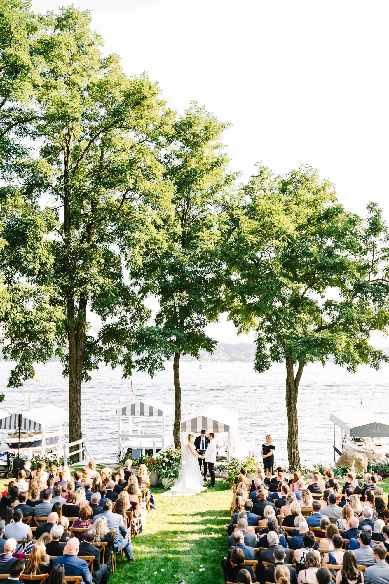 Outdoor wedding ceremony at Lake Geneva Home as bride and groom say their vows overlooking all the guests.. Outdoor wedding ceremony at Lake Geneva Home as bride and groom say their vows overlooking all the guests..
