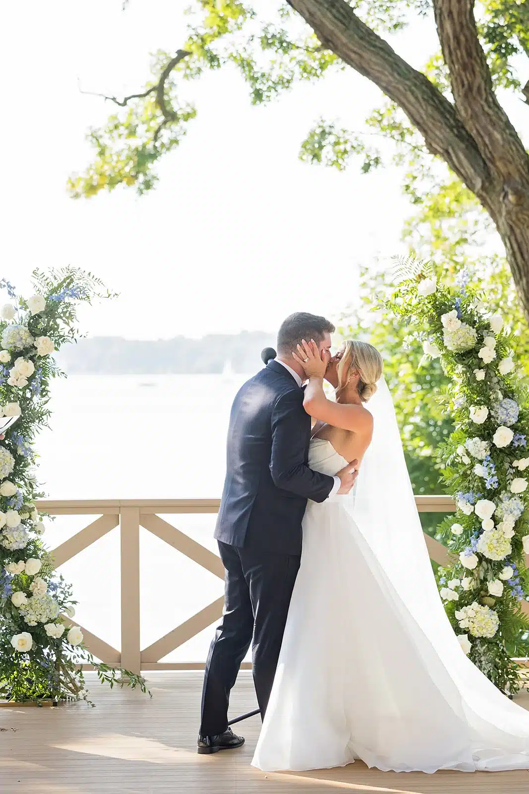 Bride and groom kiss at their wedding ceremony on the patio of The Commodore. Bride and groom kiss at their wedding ceremony on the patio of The Commodore.
