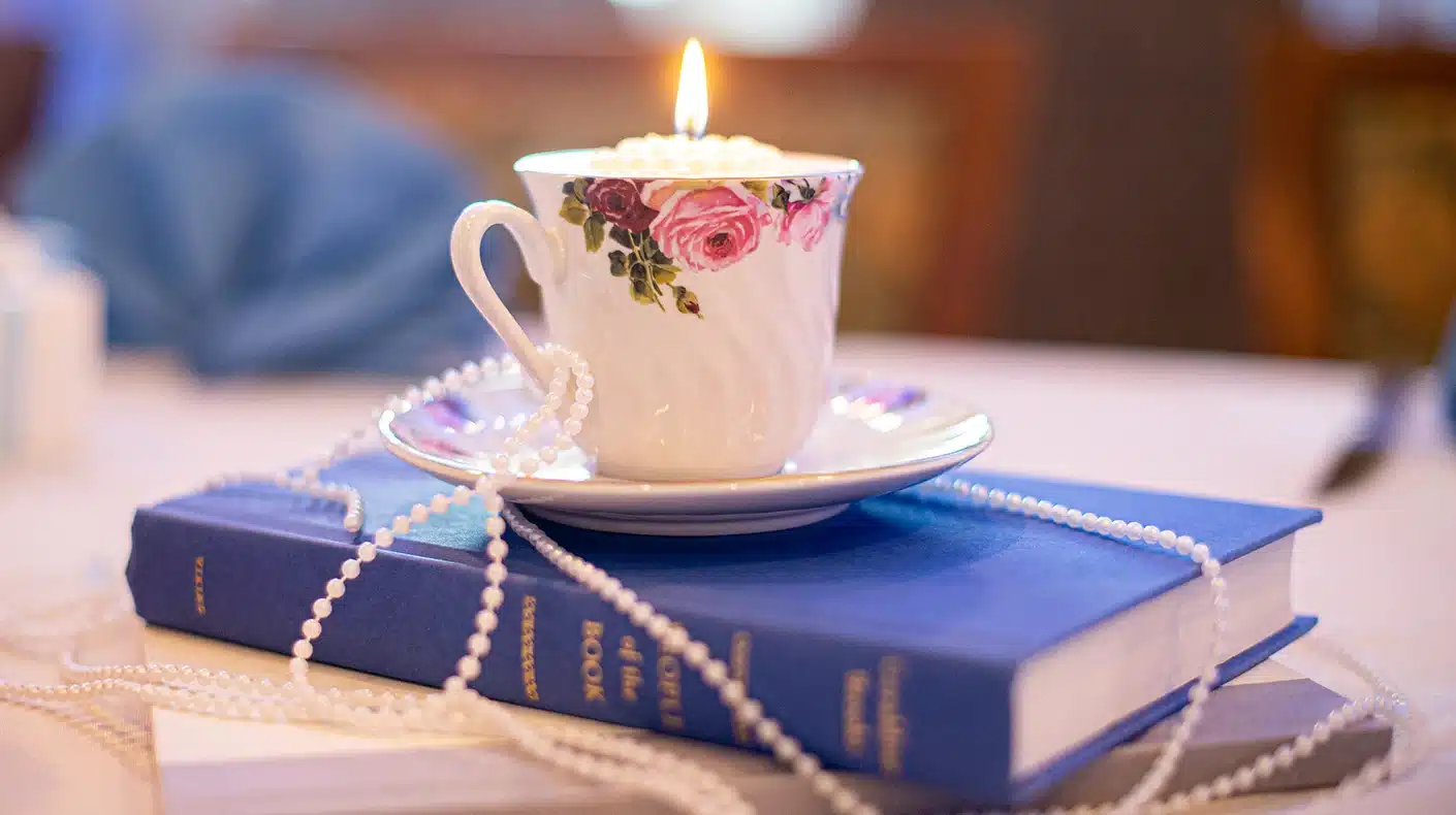 Thrifted Wedding Cup with Candle Sitting on Books Thrifted Wedding Cup with Candle Sitting on Books