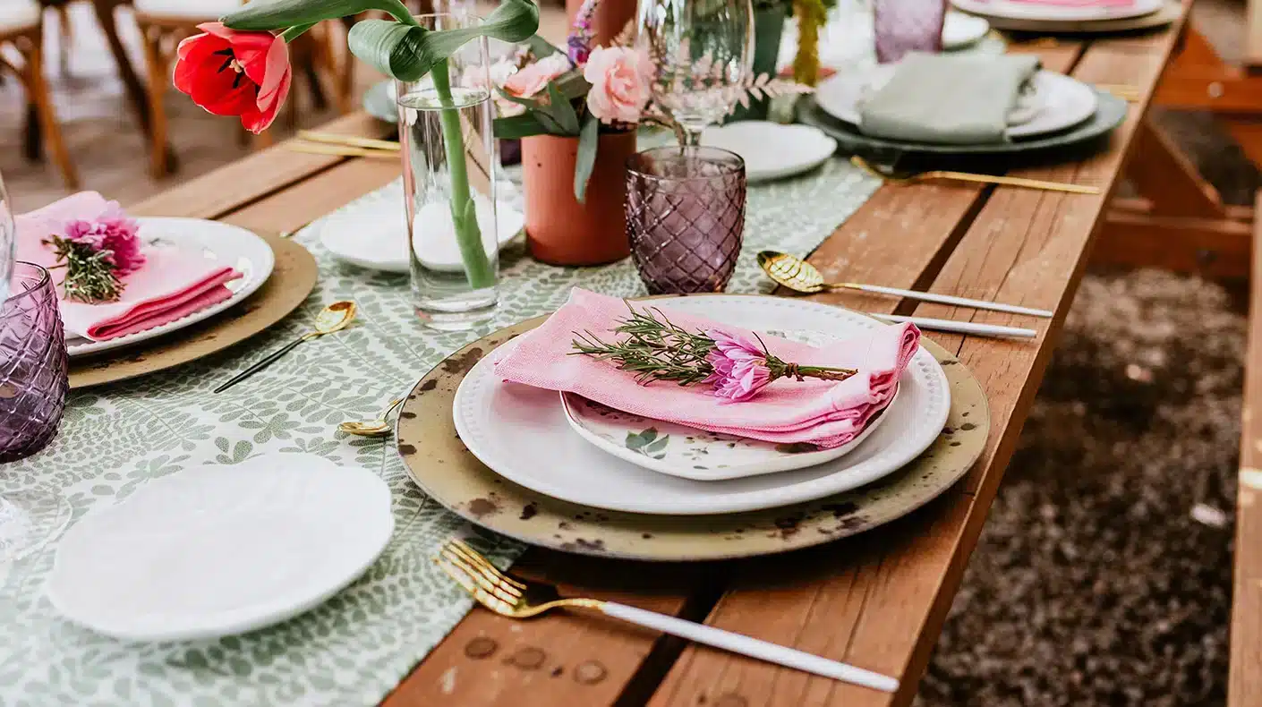 Thrifted Wedding Place setting with charger, white plate and pink napkin with flower on top. Thrifted Wedding Place setting with charger, white plate and pink napkin with flower on top.