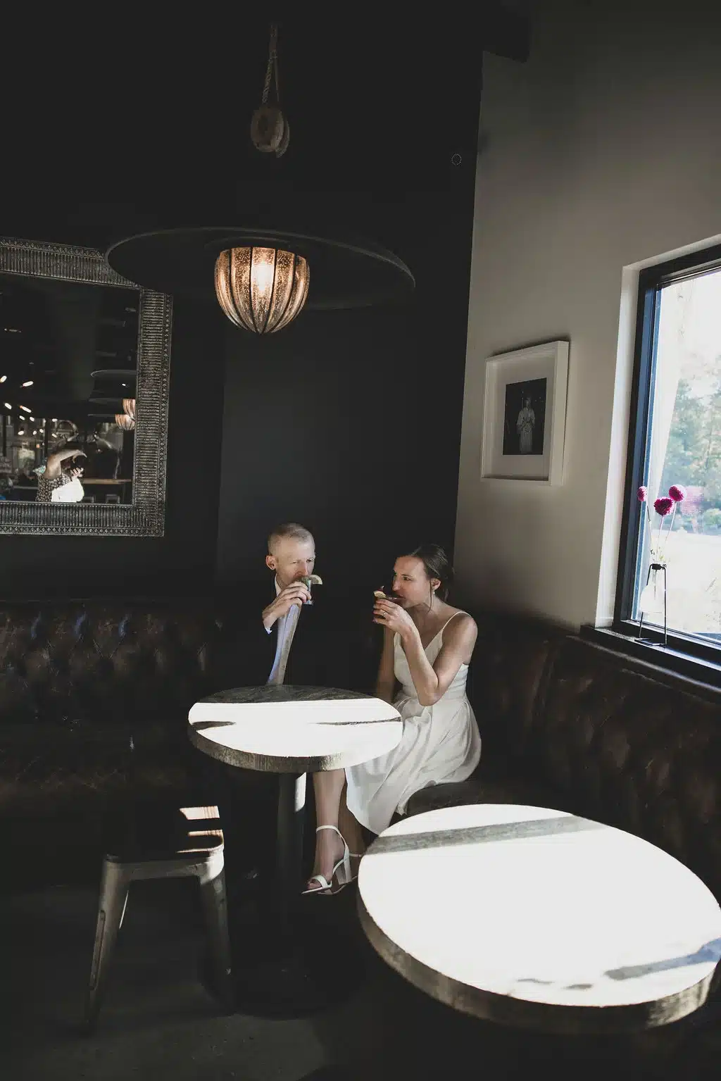 Bride and groom sit at small table at CUT in Fish Creek, Door County to have a celebration dinner after elopement. Bride and groom sit at small table at CUT in Fish Creek, Door County to have a celebration dinner after elopement.