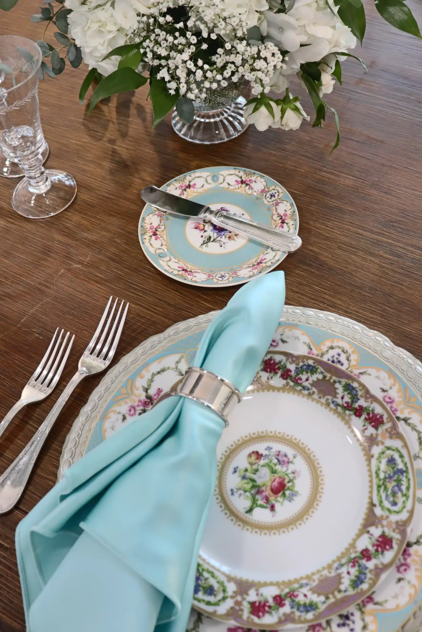 Antique place setting for wedding with aqua blue napkin and colorful plates. Antique place setting for wedding with aqua blue napkin and colorful plates.