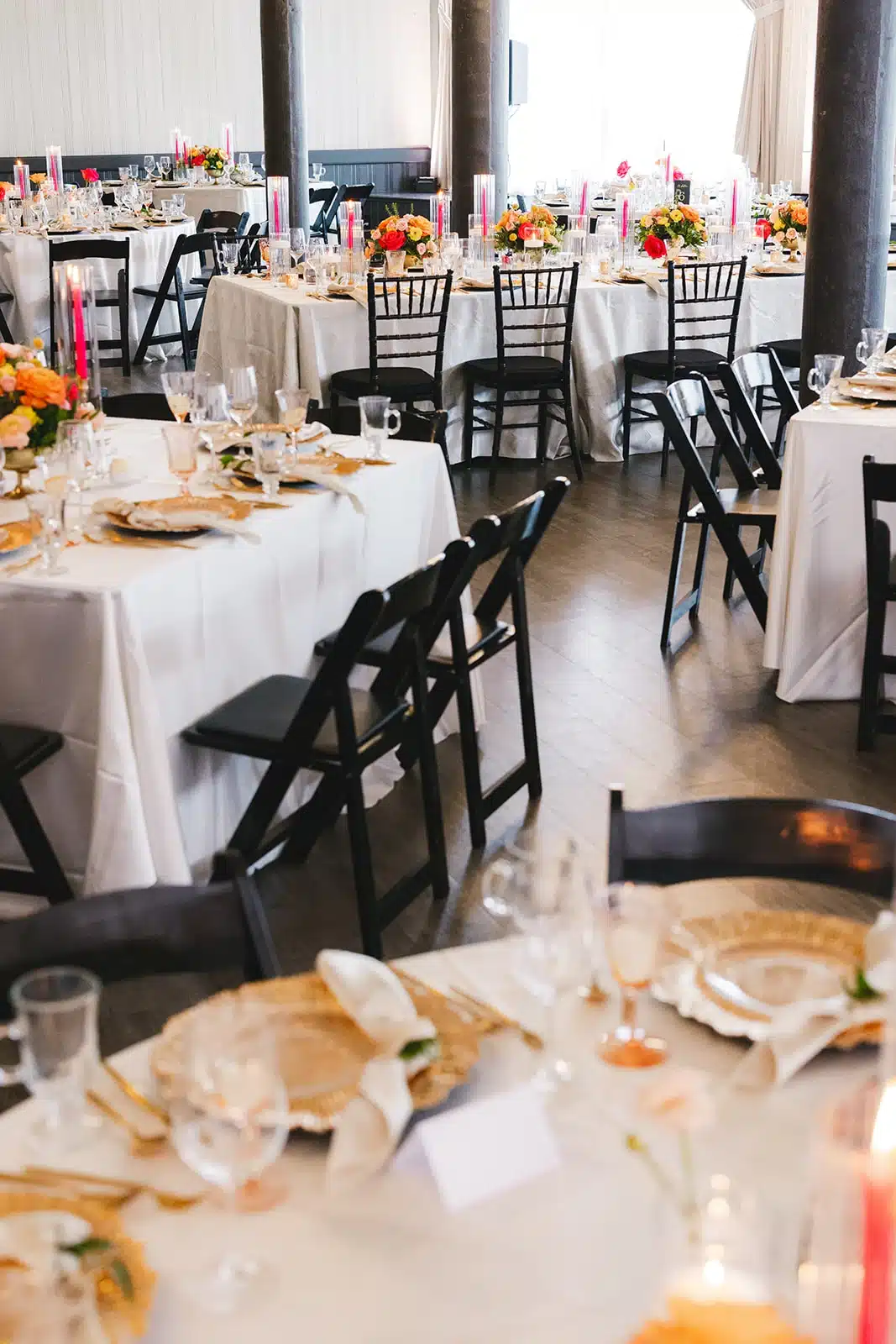 Wedding reception decor at The Pritzlaff featuring black chairs, white linens, and bright colored flowers. Wedding reception decor at The Pritzlaff featuring black chairs, white linens, and bright colored flowers.