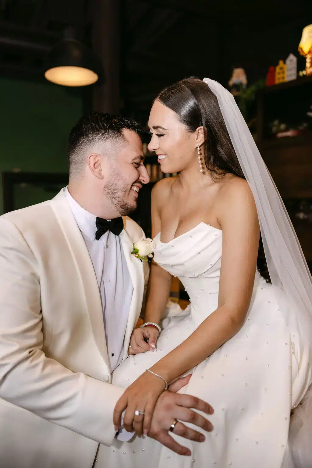 Bride and groom close together and she sits on the bar at The Legend at Brandybrook. Bride and groom close together and she sits on the bar at The Legend at Brandybrook.