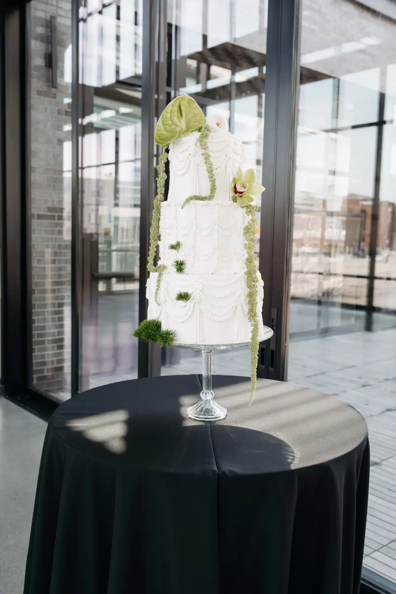 Three tier wedding cake on crystal pedestal stand. Featuring vintage piping details and simple floral accents by Whisk Chick. Three tier wedding cake on crystal pedestal stand. Featuring vintage piping details and simple floral accents by Whisk Chick.