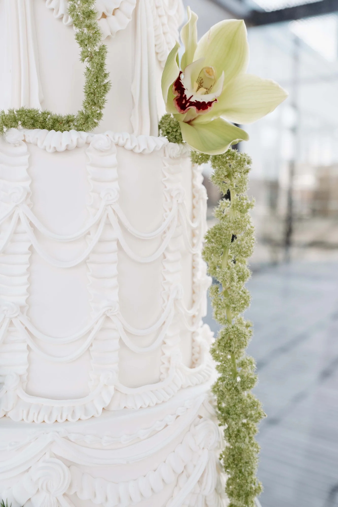 Close up photo of three tier white wedding cake from Whisk Chick with vintage piping details. Close up photo of three tier white wedding cake from Whisk Chick with vintage piping details.