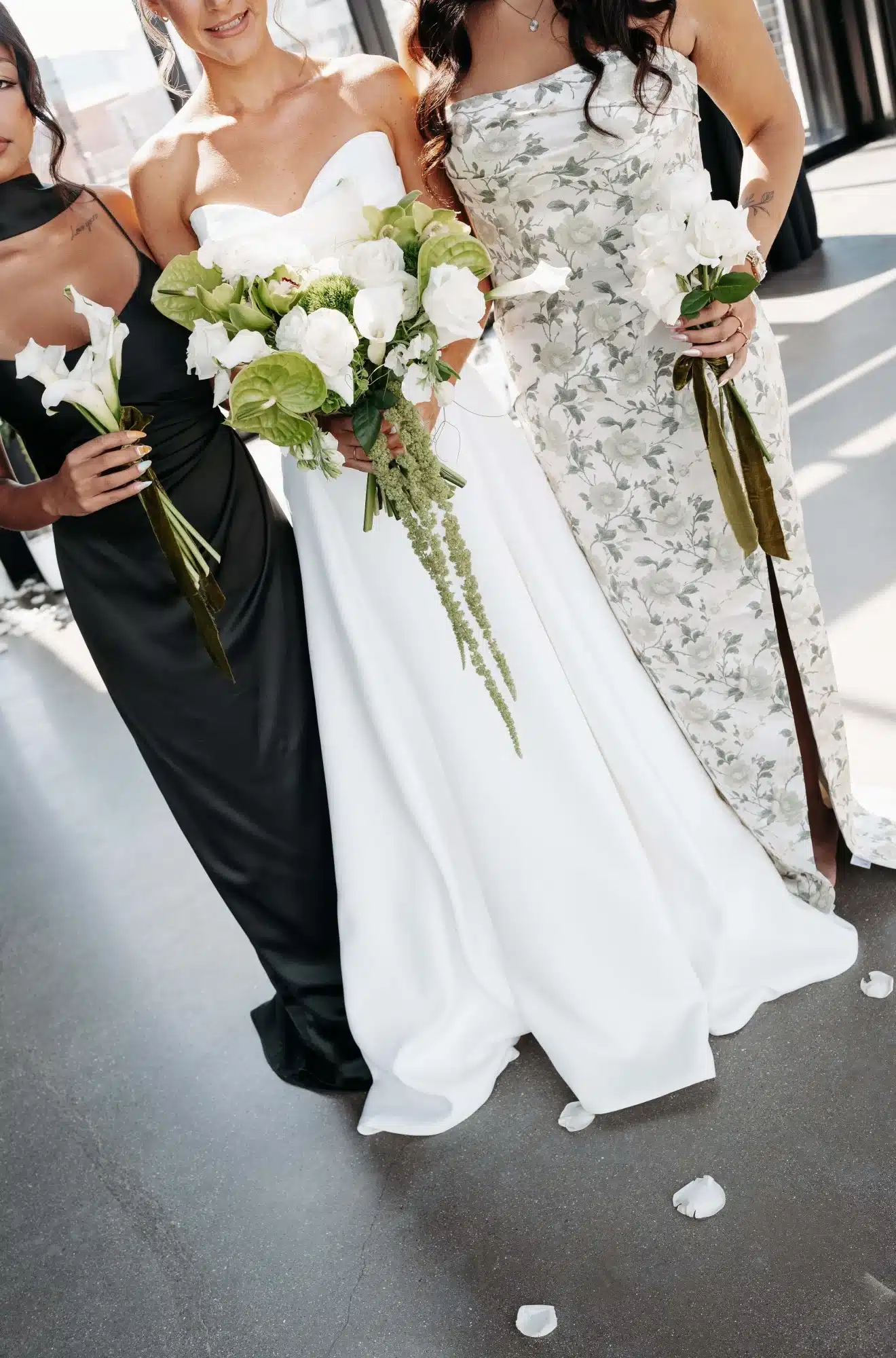 Close up photo of strapless white bridal gown, green floral dress and olive green dress from Miss Ruby Bridal Boutique. Close up photo of strapless white bridal gown, green floral dress and olive green dress from Miss Ruby Bridal Boutique.