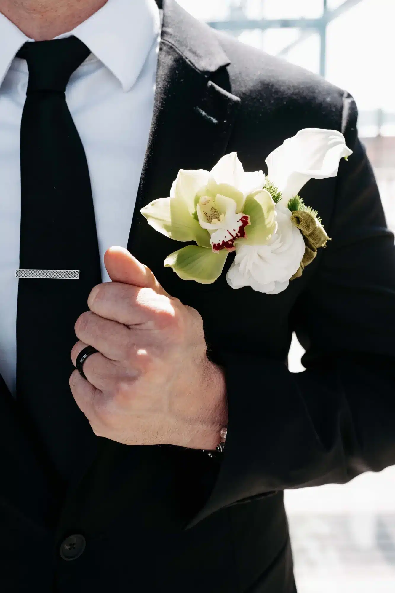 Orchid Boutonniere against black suit created by Reflections of You. Orchid Boutonniere against black suit created by Reflections of You.