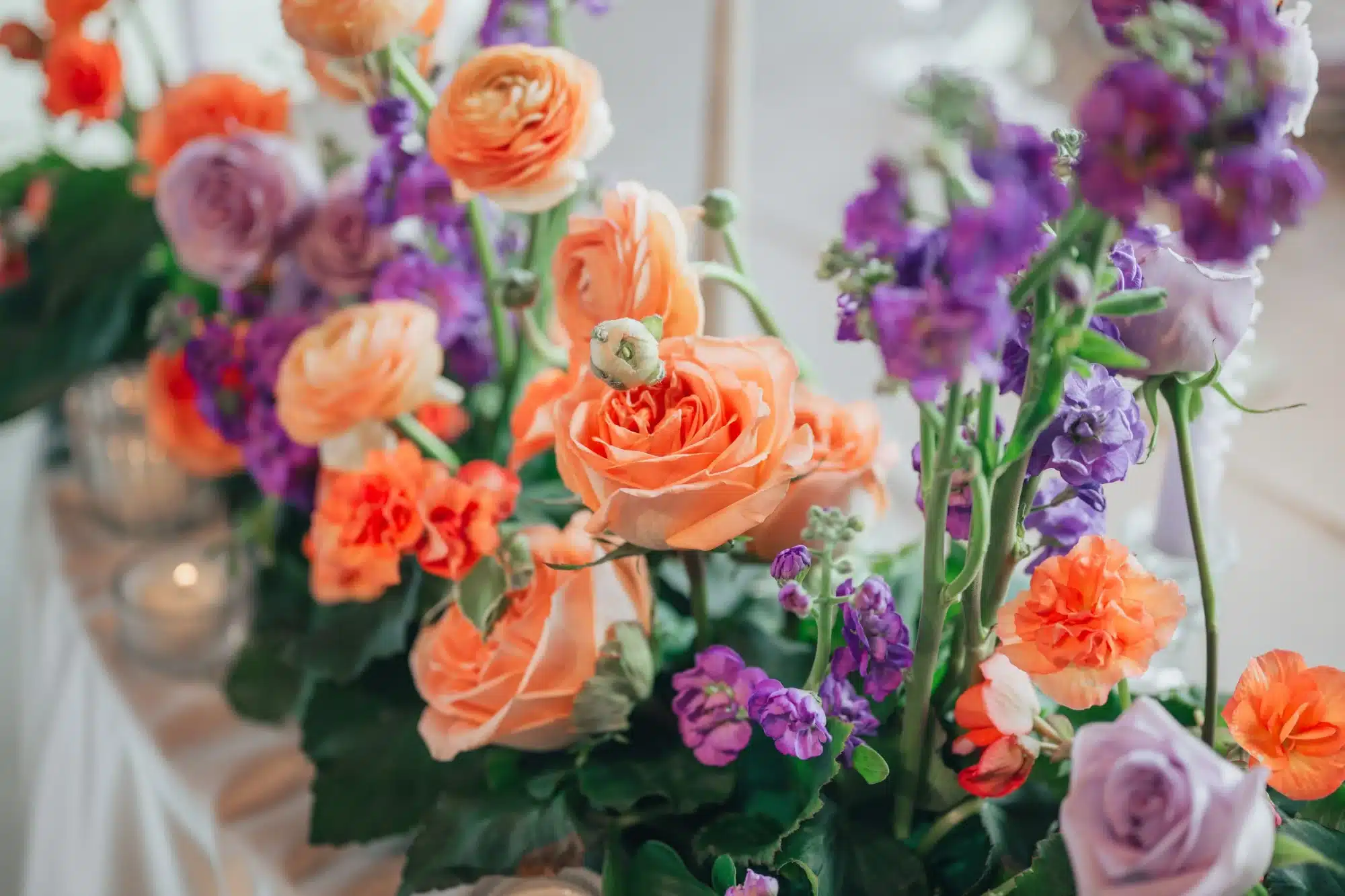 Floral arrangements by Vines and Violet with purple and orange flowers. Floral arrangements by Vines and Violet with purple and orange flowers.