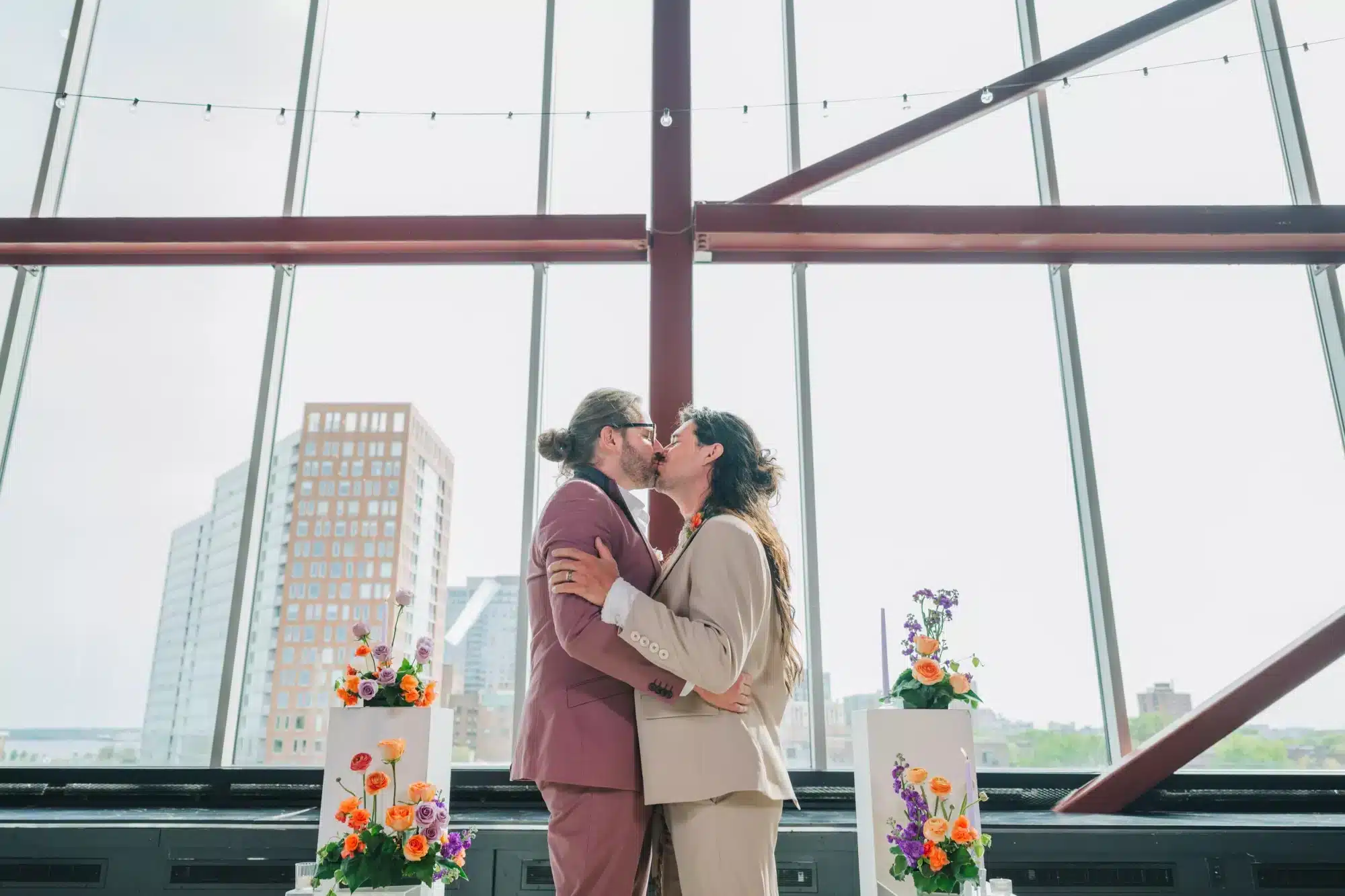 Grooms kiss at wedding ceremony at Jan Serr Studio.