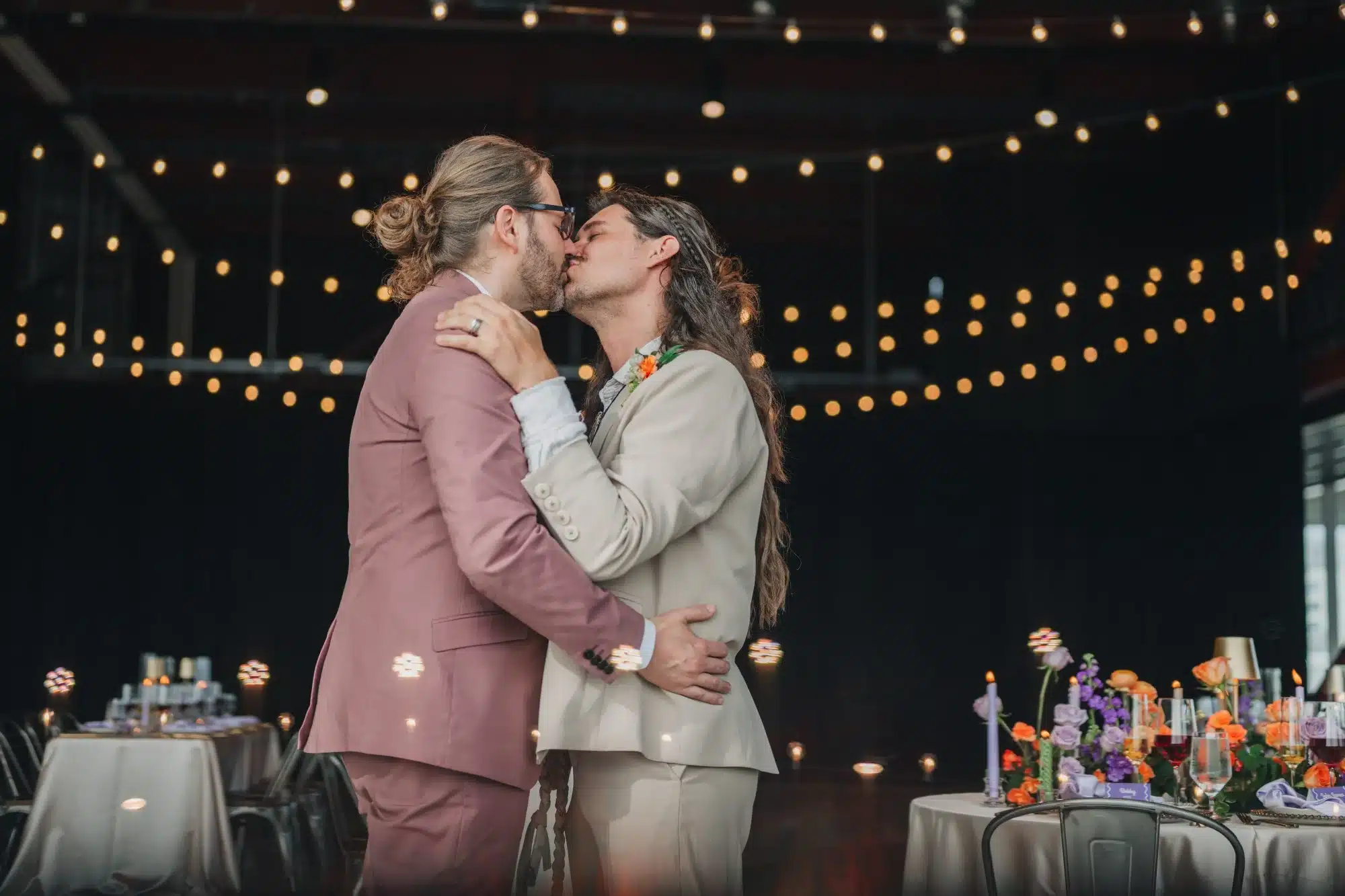 Grooms kissing with cafe lights shining behind them at Jan Serr Studio. Grooms kissing with cafe lights shining behind them at Jan Serr Studio.