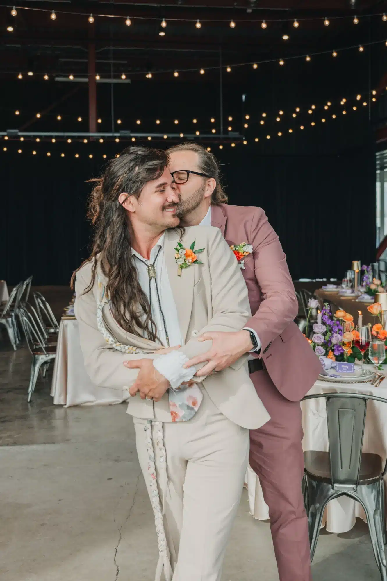 Grooms snuggling together as one kisses the other from behind. Grooms snuggling together as one kisses the other from behind.