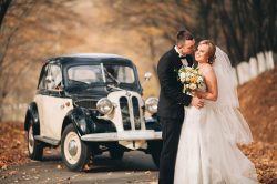 bride and groom with vintage car in autumn