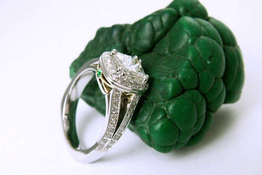 Artistically posed engagement ring leaning against green stone by Steven Paul Designs