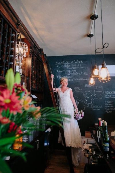 Bride standing with flowers in forefront at Corvina Wine Company