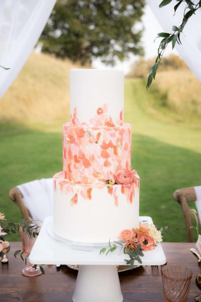 Wedding Cake by Simma's Bakery with flower accents by Bank of Flowers. Coral and Gold wedding cake.