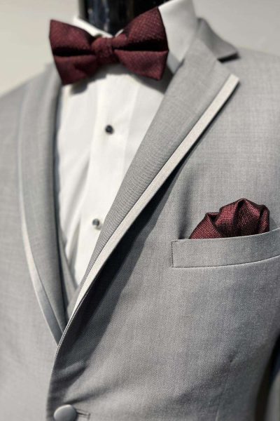 Grey tux with maroon bow tie and pocket square at Sandra D's Bridal Boutique in Watertown