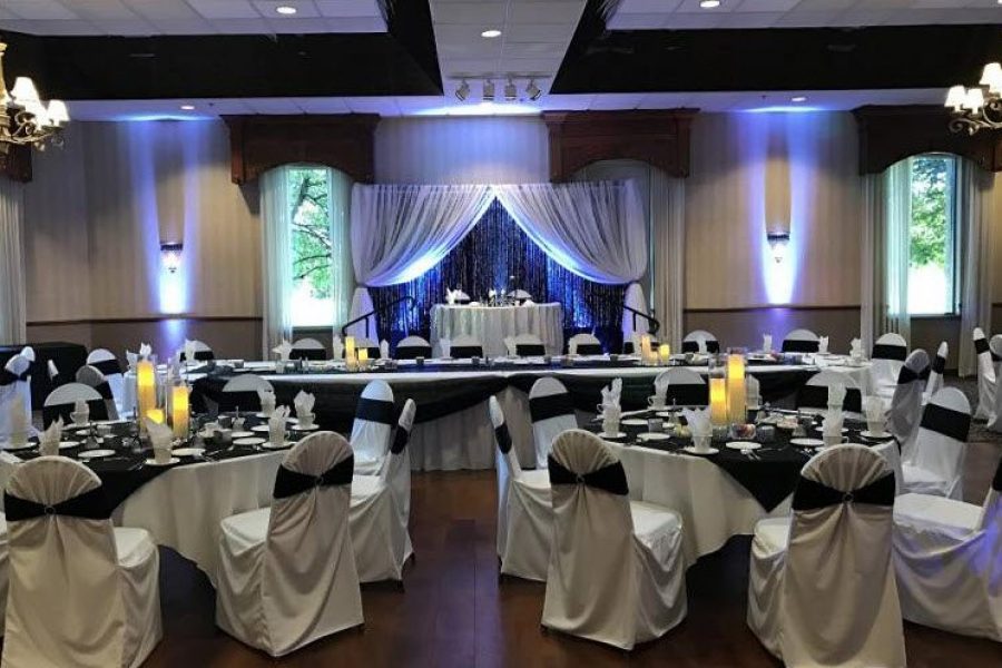 Reception area with draped head table. White linens and navy blue chair ties and napkins.