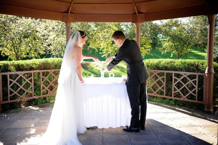 Bride and Groom lighting candles in Gazebo at Davians Catering & Conference Center weddings