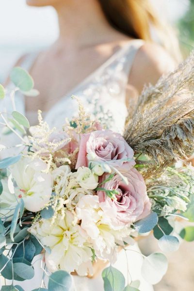 Blush and pampas grass wedding bouquet with white floral accents and greenery. Flowers by Bank of Flowers, WI.