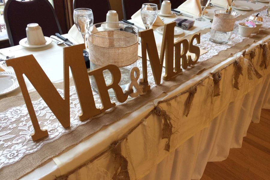 Head table with bride and groom wooden sign