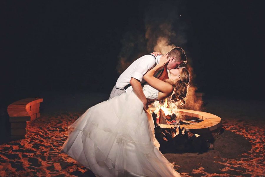Groom dips & kisses bride by fire-pit at night | SB Photography and Design