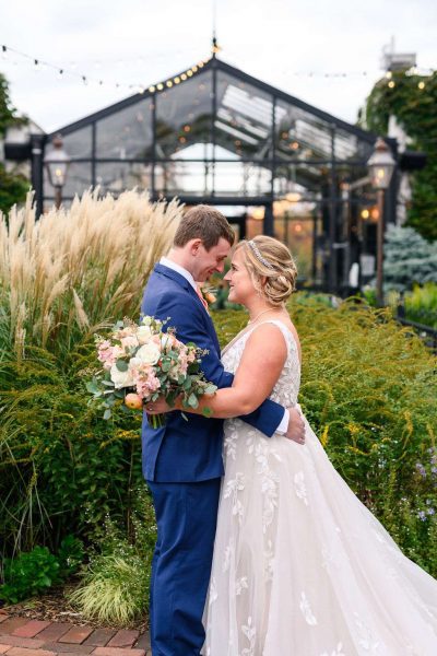 wedding bouquet with couple accented infront of greenhouse at The Atrium done by Bank of Flowers in Wisconsin.