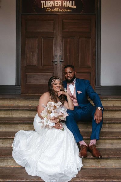 Bride and groom pose on steps at Turner Hall Ballroom in Milwaukee, WI.