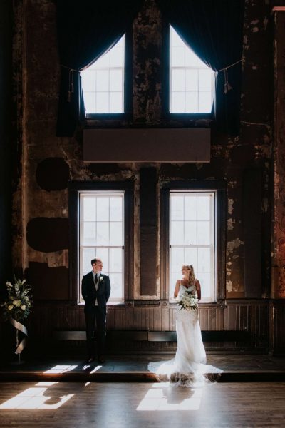 Bride and groom stand in the light of beautiful windows at Turner Hall Ballroom