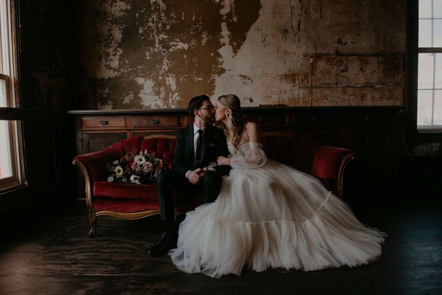Bride and groom kiss on elegant sated at Turner Hall Ballroom in Milwaukee.