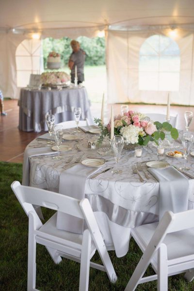Reception tables adorned with flowers inside the tent