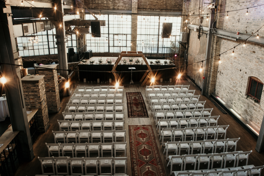The Cooperage has white chairs and soft yellow lights ready for an upcoming wedding service.