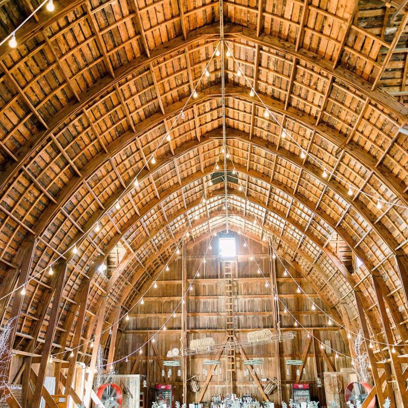 Interior of The Hayloft barn with arched ceilings and light strings