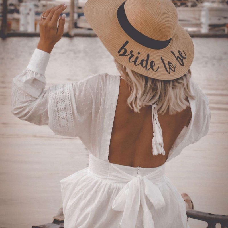 Chelsey shows off her bride to be straw hat at her engagement party