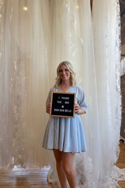 Future bride holding sign that reads 