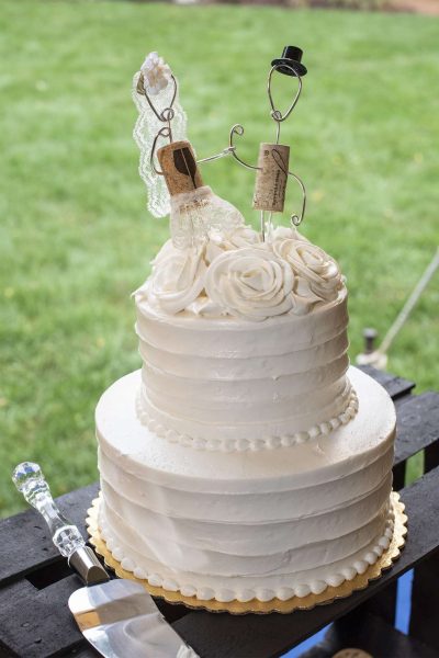 Wedding cake with cork person cake toppers.
